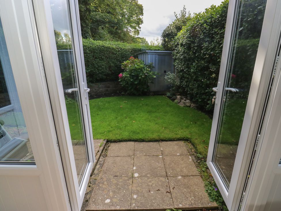 A garden with grass and paving stones at 27 Calton terrace Skipton