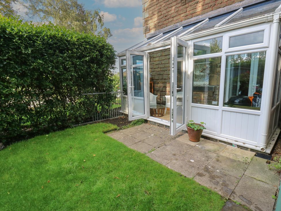 A conservatory with glass doors and a plant pot at 27 Calton terrace in Skipton