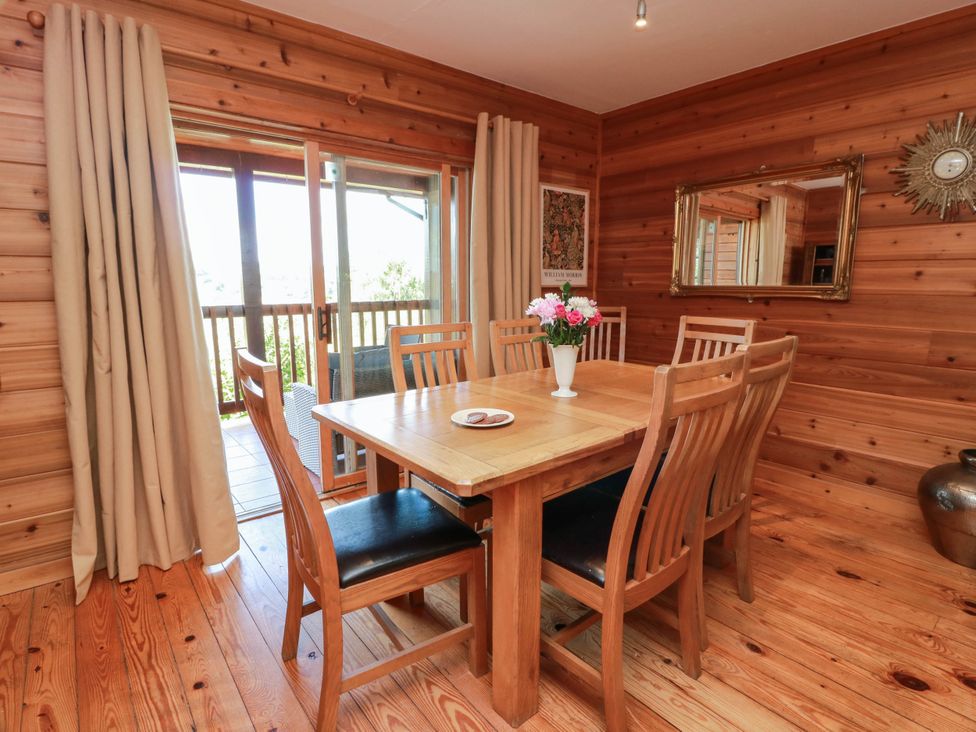 A dining room with a wooden table and chairs at Deer’s Leap