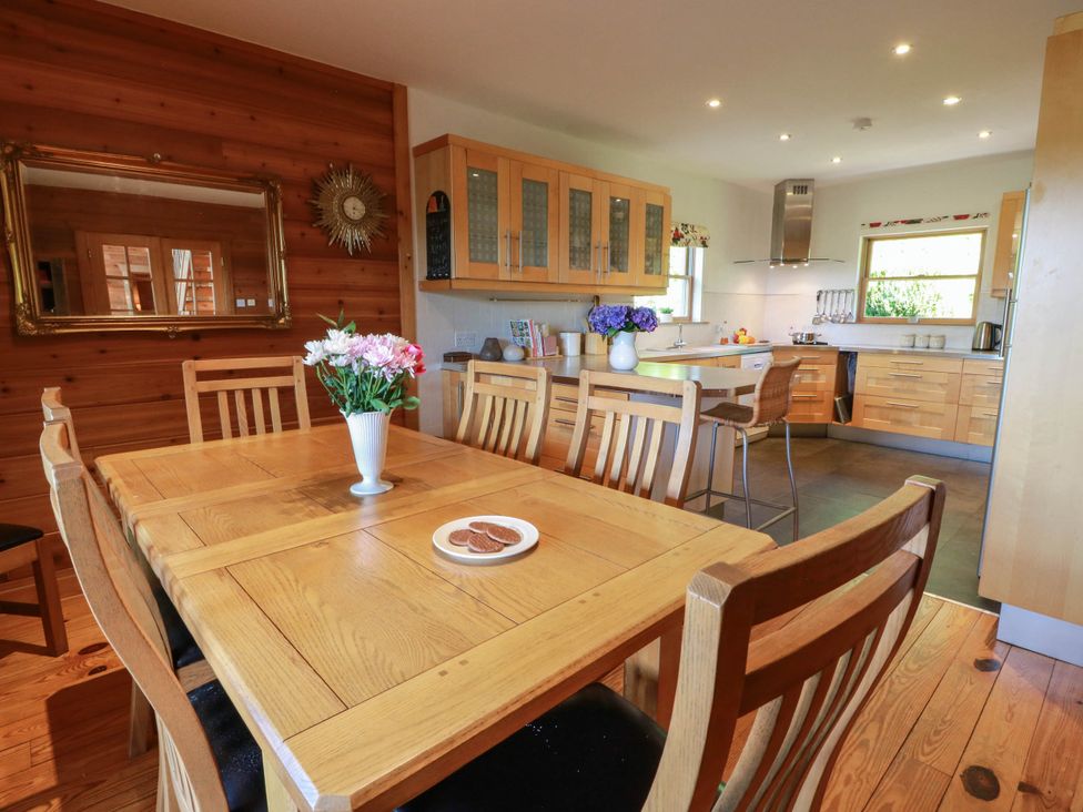 A kitchen with a dining table and wooden cabinets at Deer’s Leap