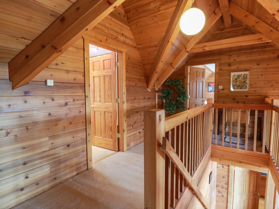A hallway with wooden walls and doors at Deer’s Leap