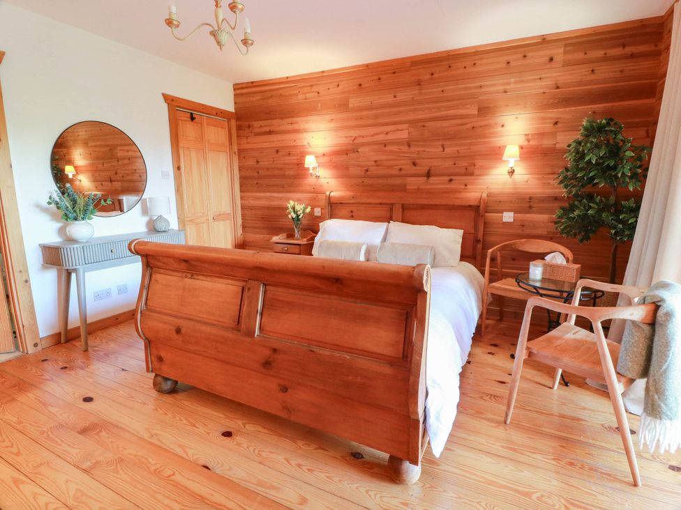 A bedroom with a bed and side table at Deer’s Leap