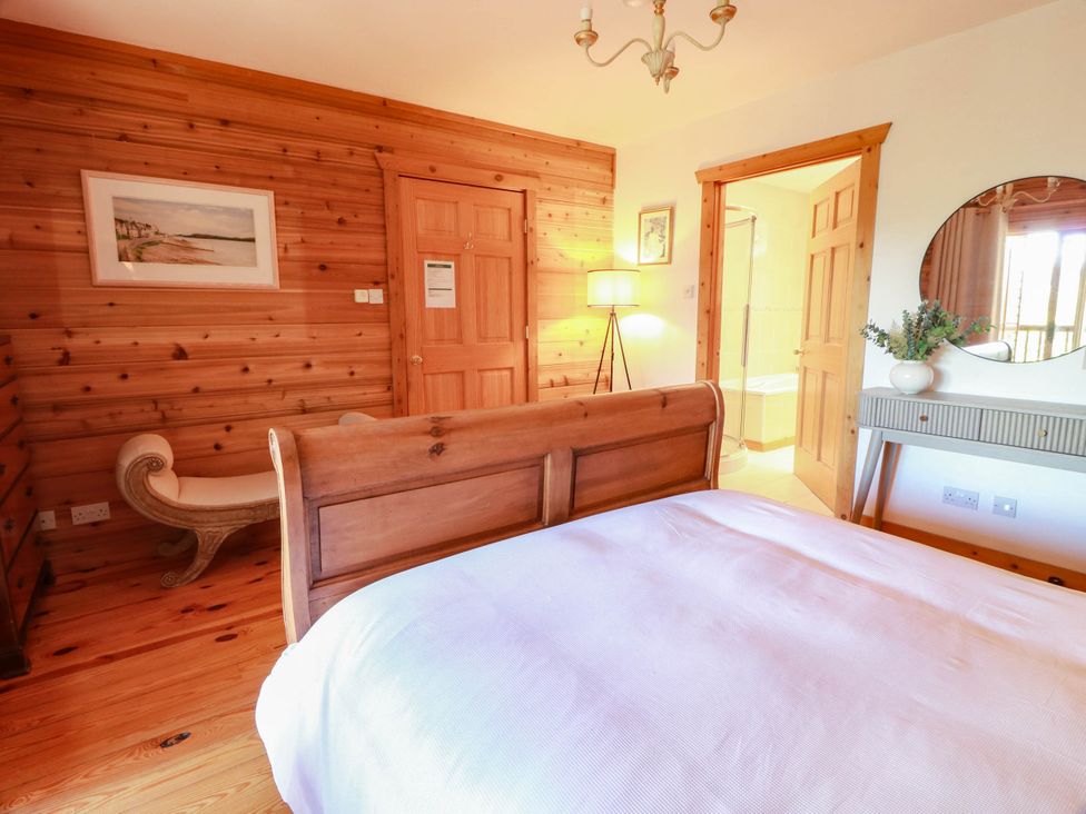 A bedroom with wooden walls and furniture at Deer’s Leap