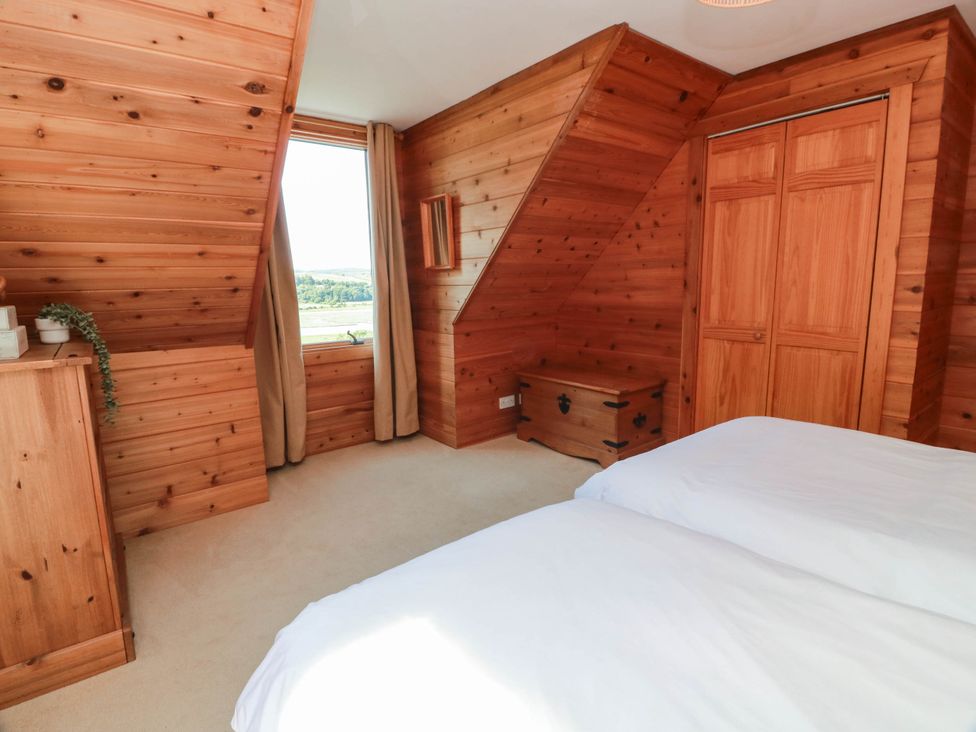 A bedroom with wooden walls and furniture at Deer’s Leap 