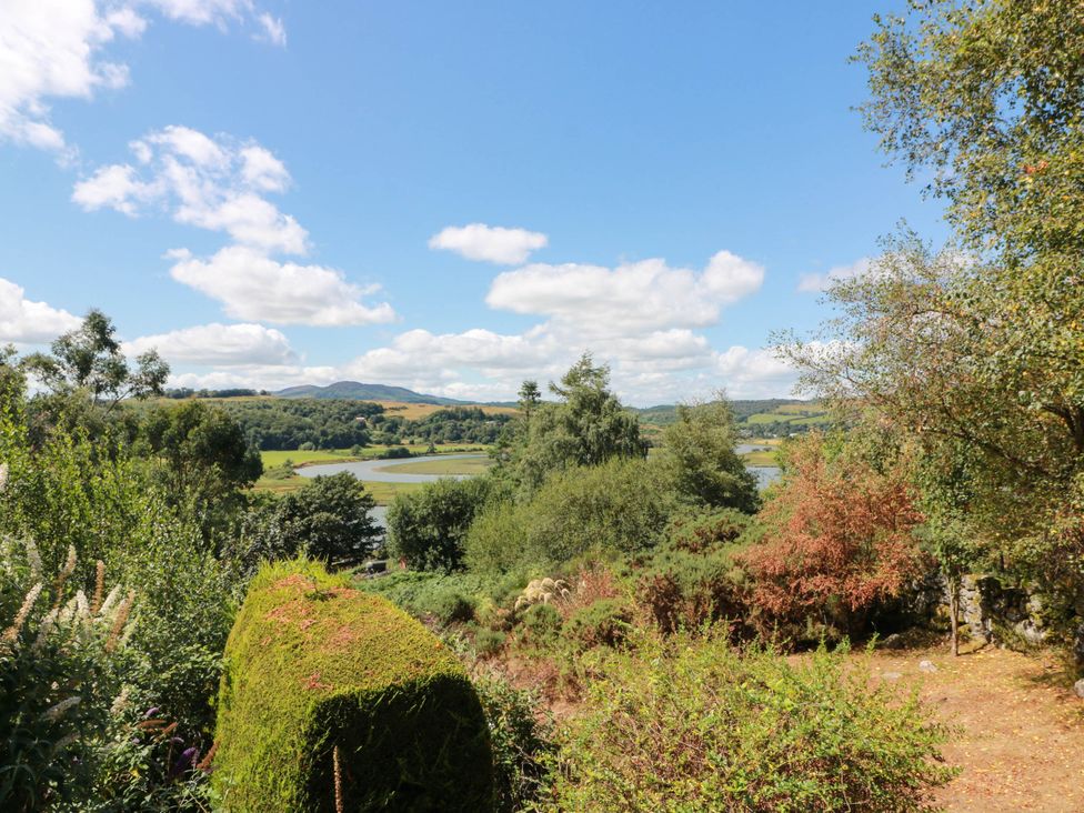 A garden view with trees and a lake at Deer’s Leap