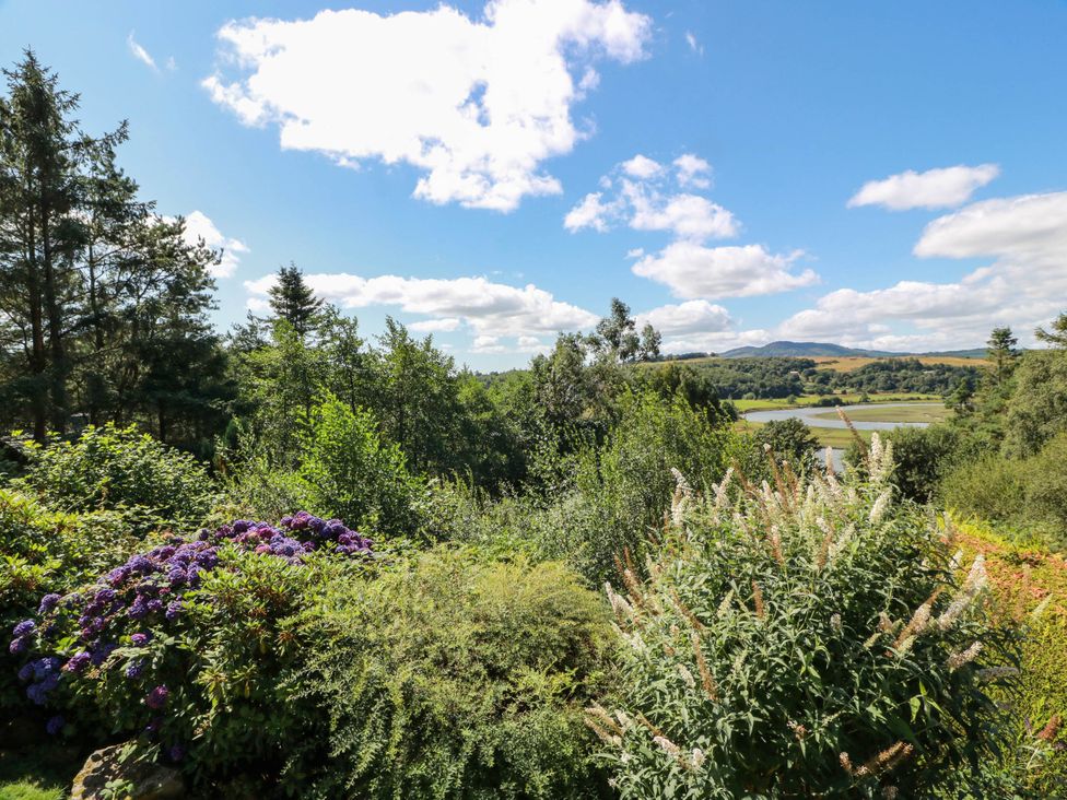 A view of flowers and trees with a river in the background at Deer’s Leap