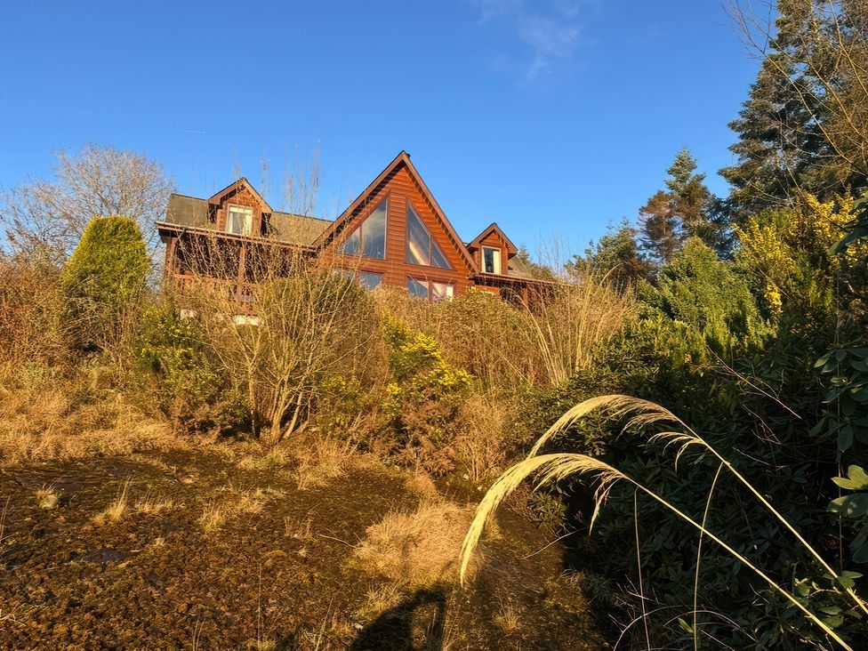 A house surrounded by trees and bushes at Deer’s Leap in Kippford