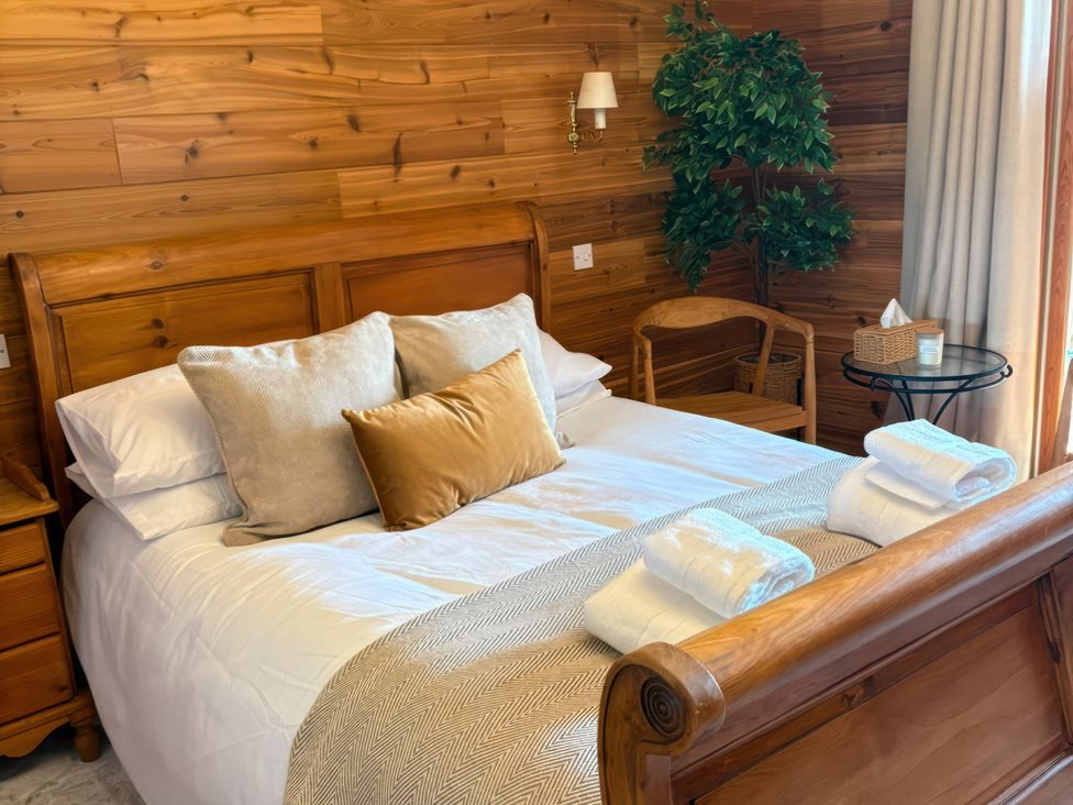 A bedroom with a bed and side table at Deer’s Leap in Kippford