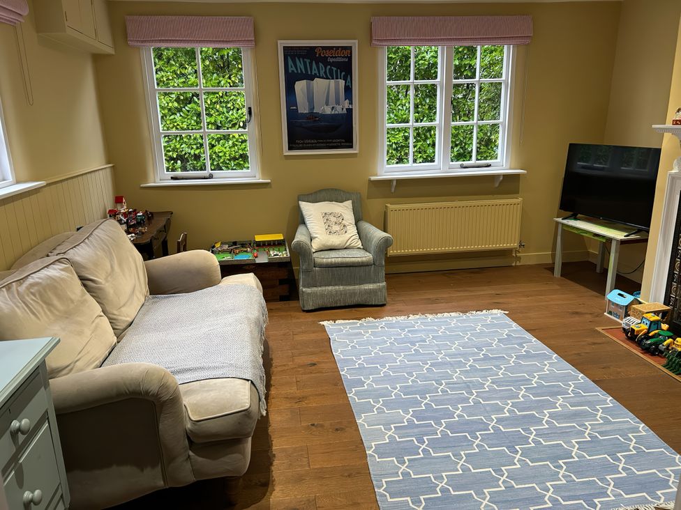 A living room with a sofa and armchair at Riverside Cottage