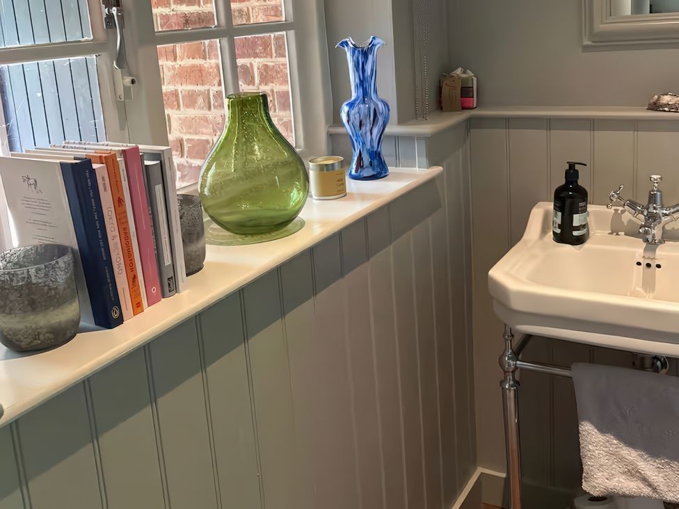 A bathroom with a sink and decorative items at Riverside Cottage