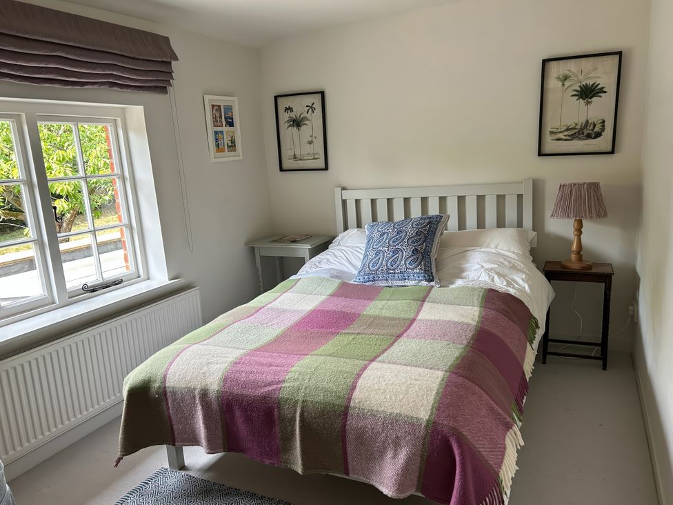 A bedroom with a bed and a nightstand at Riverside Cottage