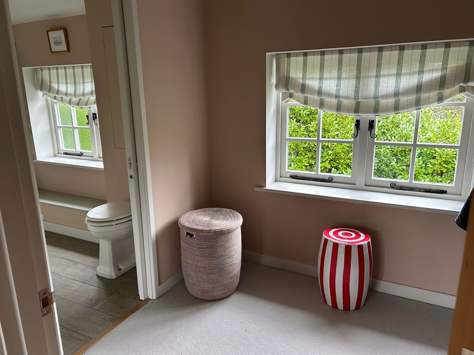 A bathroom with a toilet and a basket at Riverside Cottage