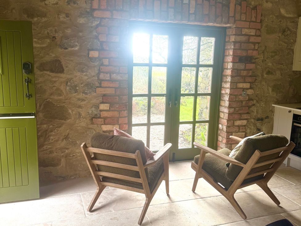 A snug with two chairs and a door at Auld Cider Makers Cottage, Portstewart, County Londonderry