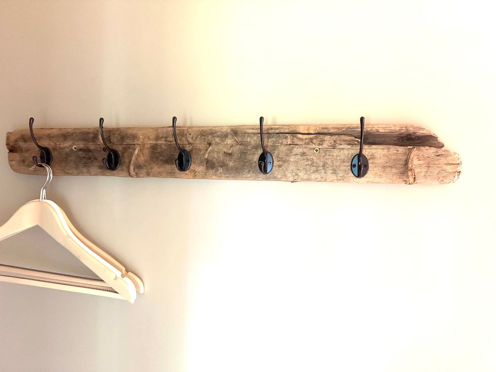 A wooden wall rack with hooks and a hanger at Auld Cider Makers Cottage, Portstewart, County Londonderry