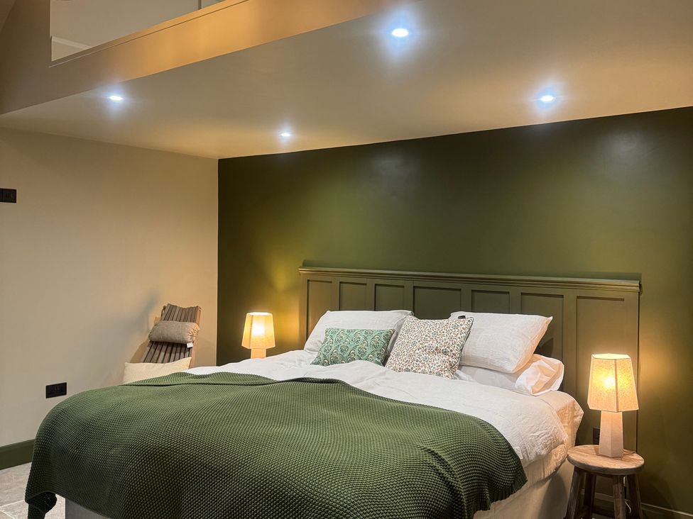 A bedroom with a bed and bedside lamps at Auld Cider Makers Cottage, Portstewart, County Londonderry