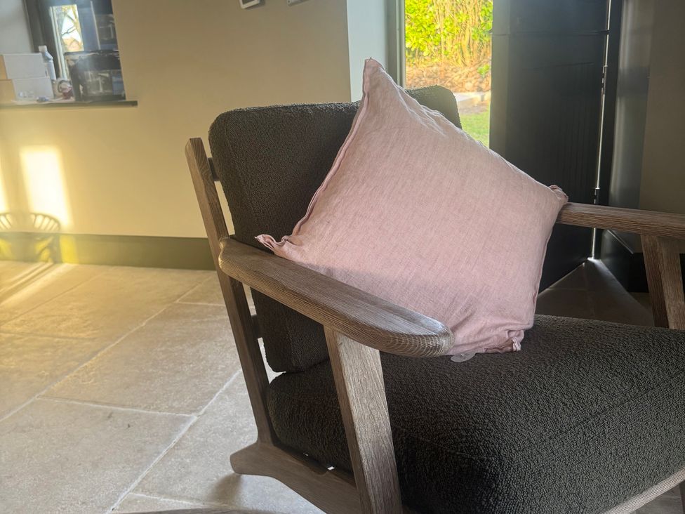 A chair with a cushion near a window in Auld Cider Makers Cottage, Portstewart, County Londonderry
