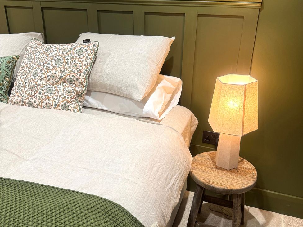 A bedroom with a bed and bedside lamp at Auld Cider Makers Cottage in Portstewart, County Londonderry
