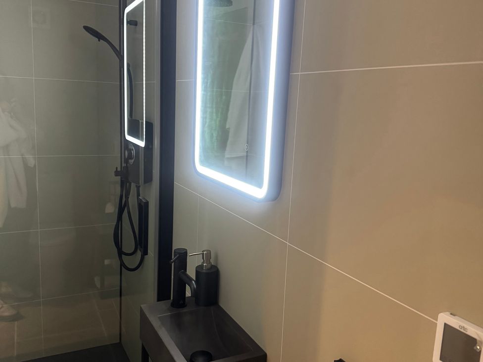 A bathroom with a shower and sink at Auld Cider Makers Cottage in Portstewart, County Londonderry