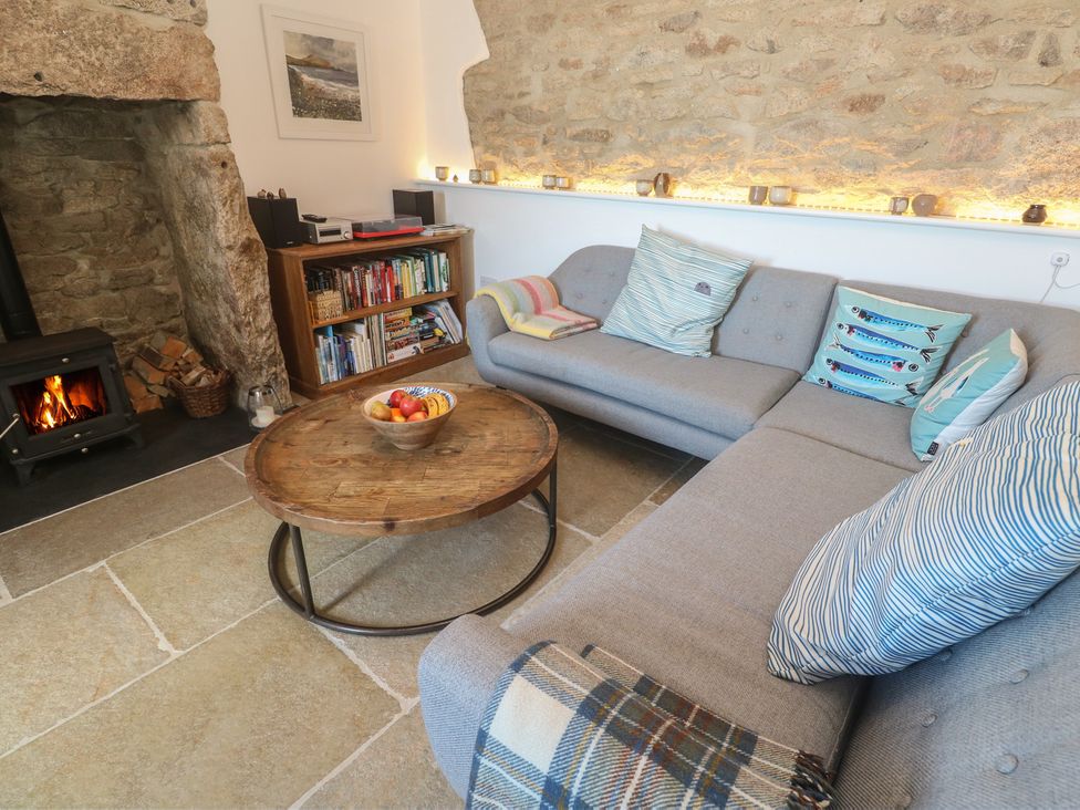 A living room with a sofa, coffee table, and fireplace at 12 Boswedden Terrace St Just