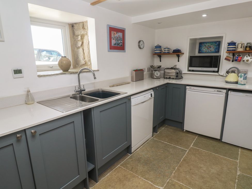 A kitchen with sink, cabinets, and appliances at 12 Boswedden Terrace, St Just