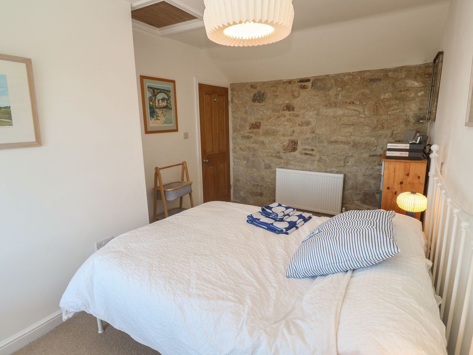 A bedroom with a bed and chair at 12 Boswedden Terrace St Just