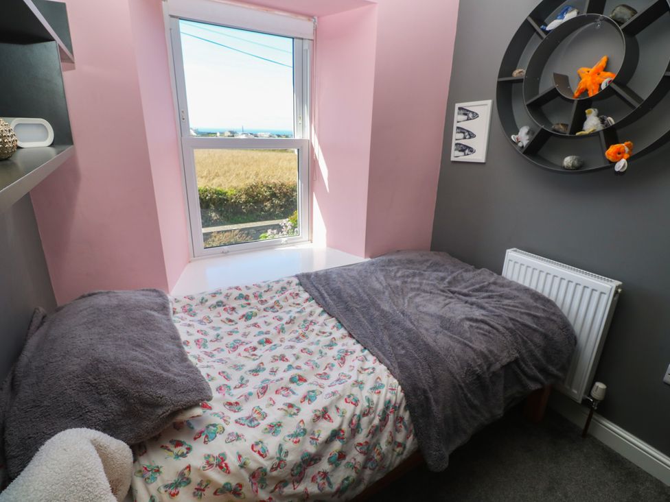 A bedroom with a bed, shelf, and window at 12 Boswedden Terrace in St Just
