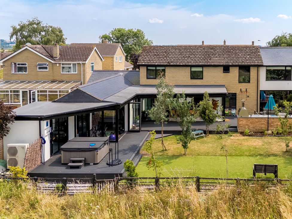 An outdoor area with a hot tub and deck at Manor Farm House in Merton near Bicester