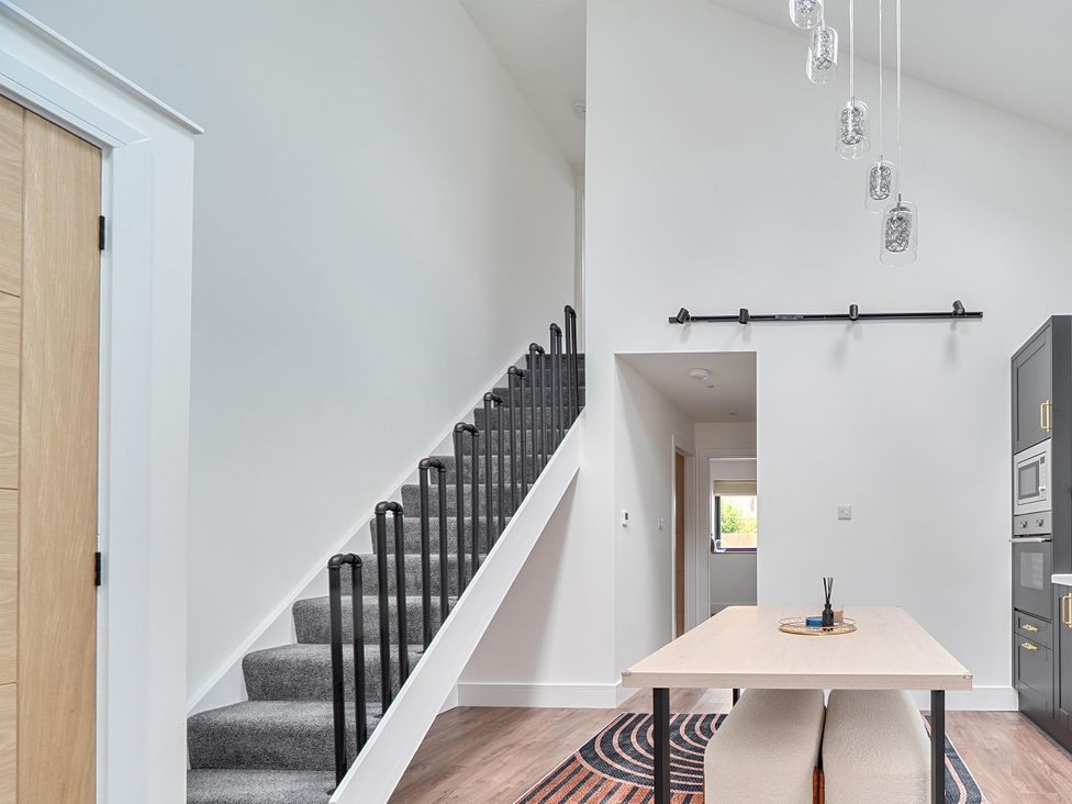A dining area with a staircase and a dining table at Manor Farm House in Merton near Bicester