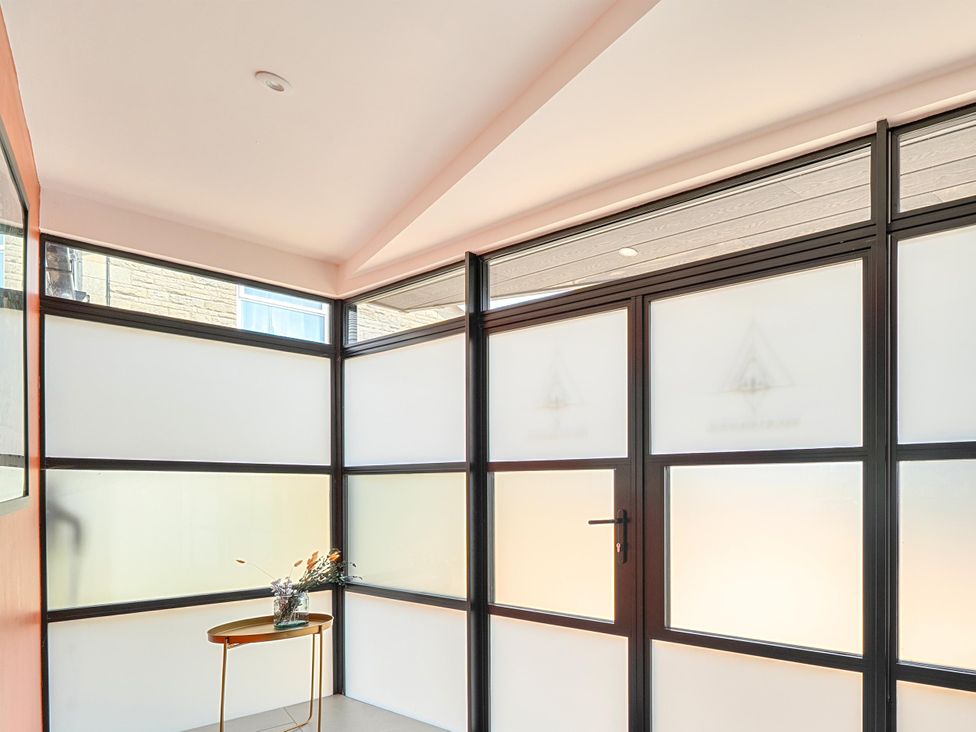 An entryway with glass panels and a table with a vase at Manor Farm House in Merton near Bicester