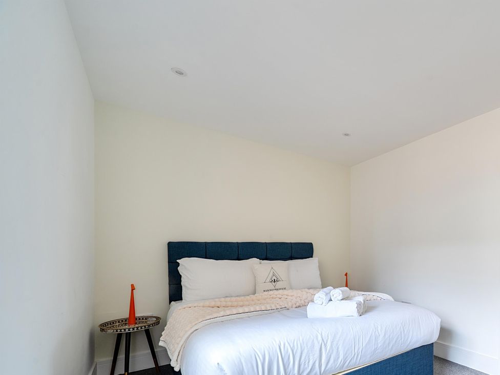 A bedroom with a bed and bedside table at Manor Farm House in Merton near Bicester