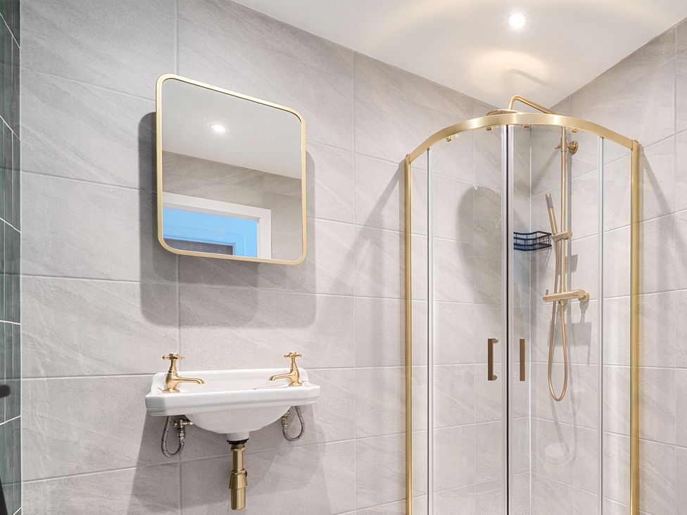 A bathroom with a shower, mirror, and sink at Manor Farm House in Merton near Bicester