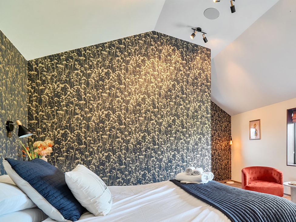 A bedroom with a bed and armchair at Manor Farm House in Merton near Bicester