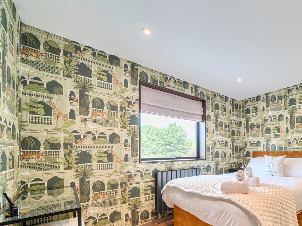 A bedroom with a bed and window at Manor Farm House in Merton near Bicester