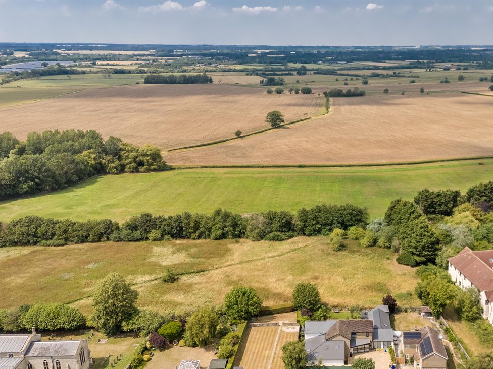 An aerial view of fields and trees with houses at Manor Farm House in Merton near Bicester