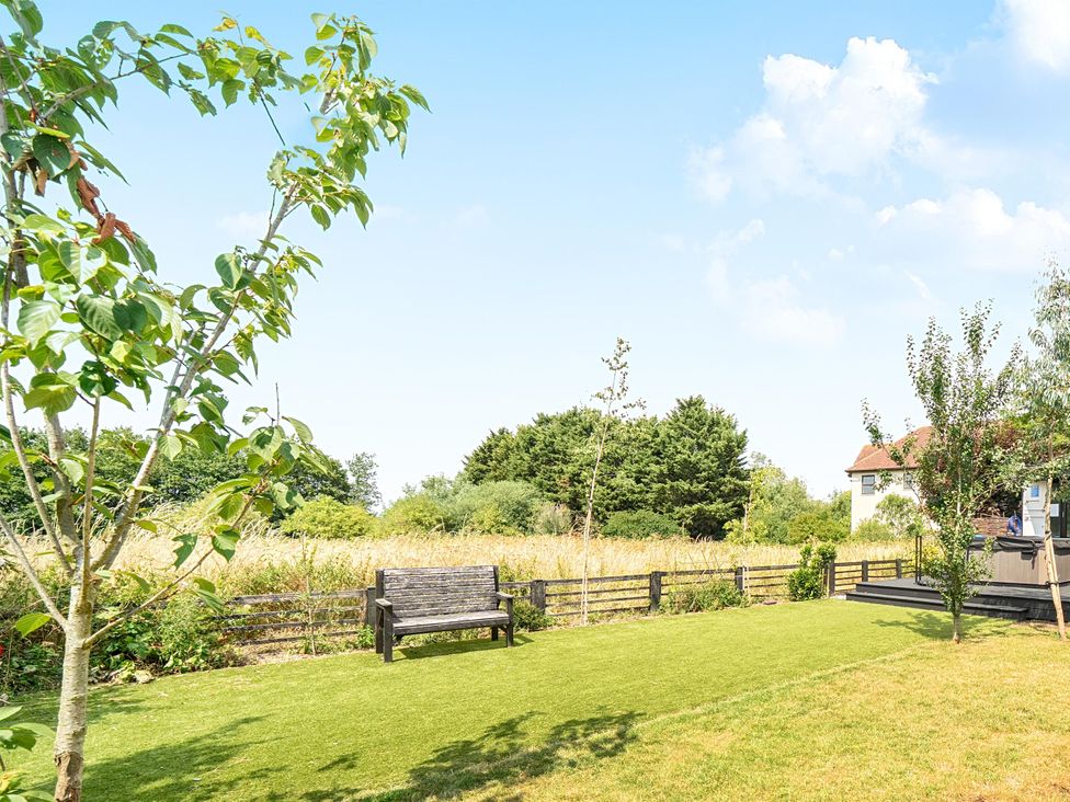 A garden with a bench and trees at Manor Farm House in Merton near Bicester