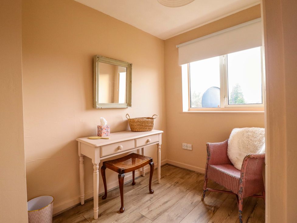 A room with a table, chair, and a mirror at 2 Horseshoe Road in Montgomery