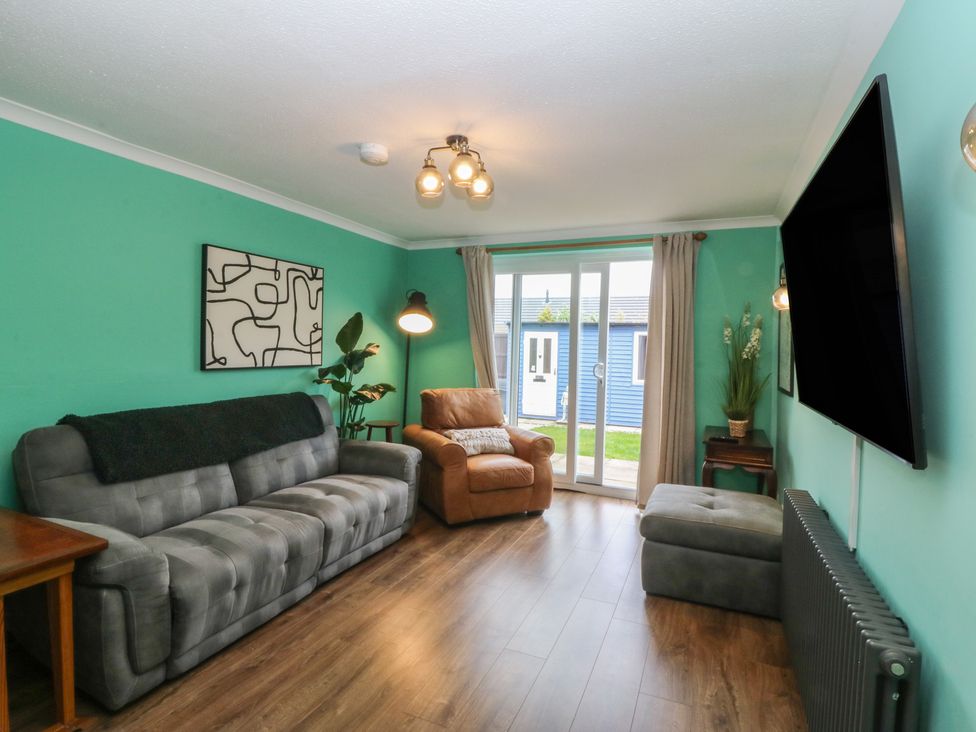 A living room with a sofa and television at 61 Lloyd Street West Llandudno
