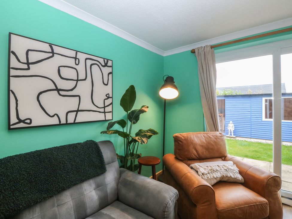 A living room with a sofa and an armchair at 61 Lloyd Street West in Llandudno