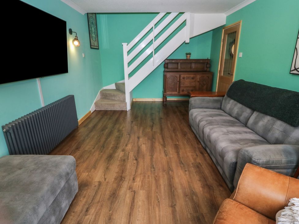A living room with a sofa and television at 61 Lloyd Street West Llandudno