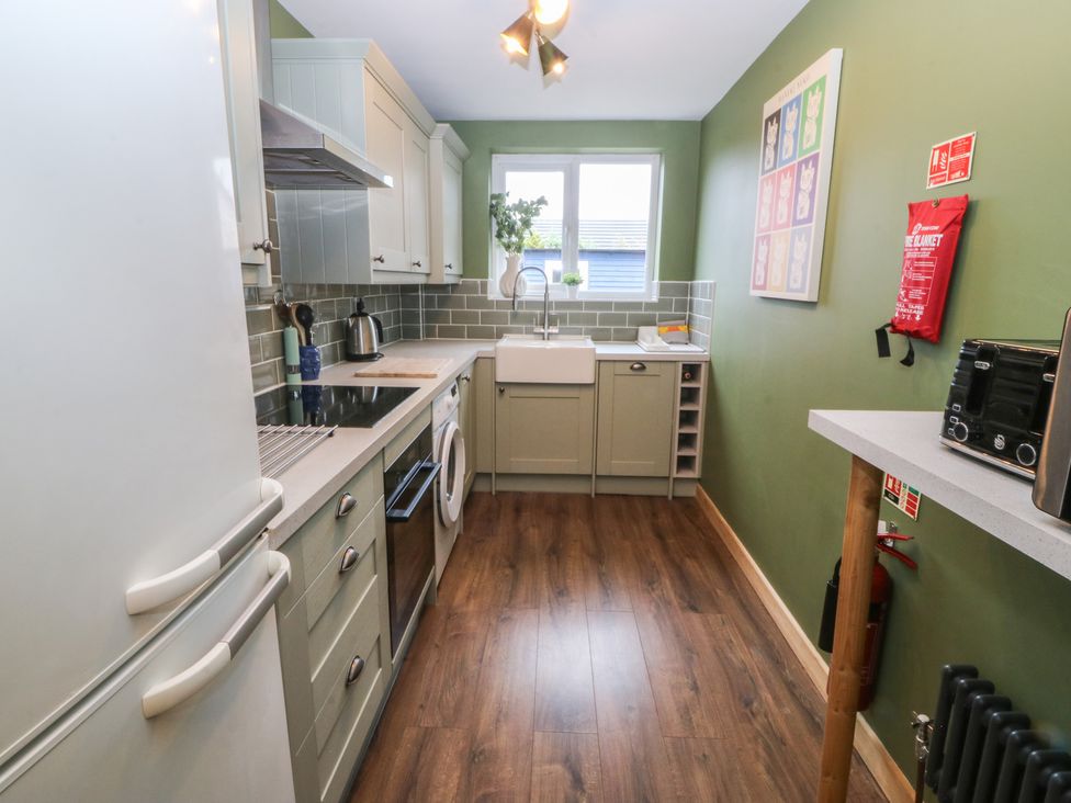 A kitchen with a sink and refrigerator at 61 Lloyd Street West Llandudno