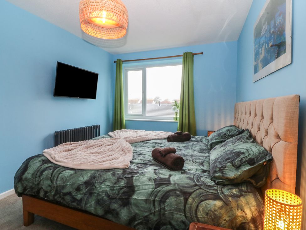 A bedroom with a bed and television at 61 Lloyd Street West in Llandudno