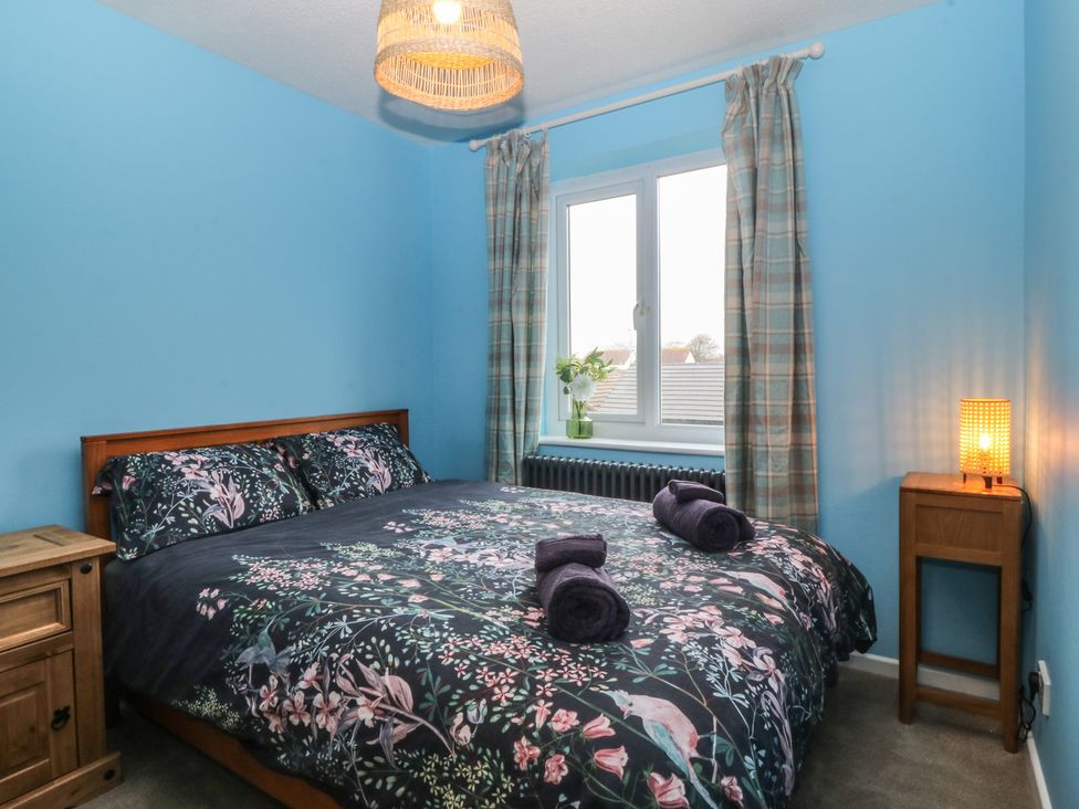 A bedroom with a bed and side table at 61 Lloyd Street West in Llandudno
