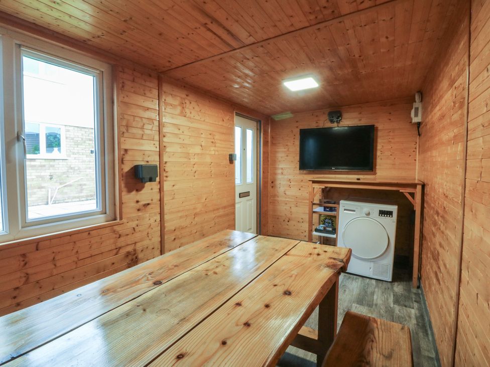 A snug with a table and television at 61 Lloyd Street West Llandudno
