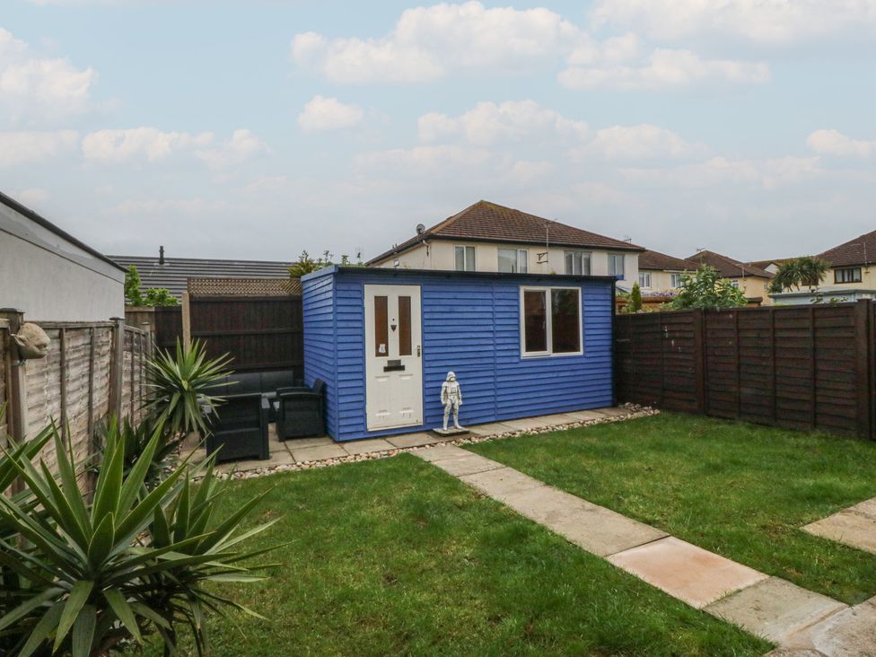 A garden with a blue shed and pathway at 61 Lloyd Street West in Llandudno