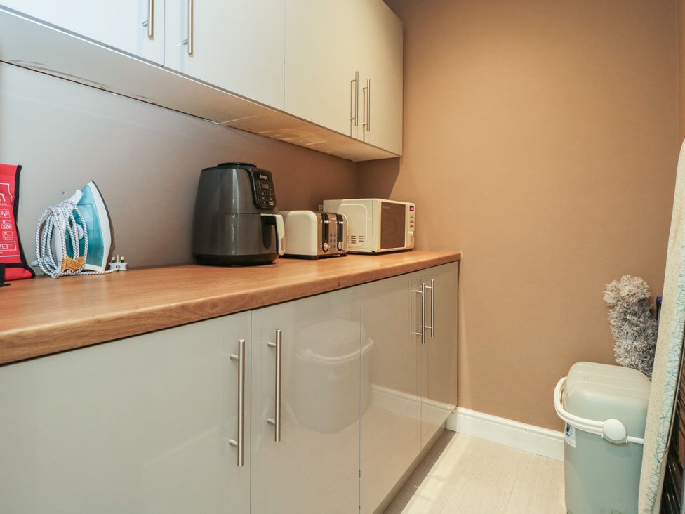 A laundry room with appliances on a countertop at Willow Cottage in Whiteparish