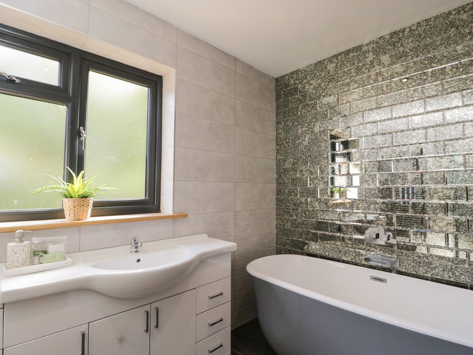 A bathroom with a bathtub and sink at Willow Cottage in Whiteparish