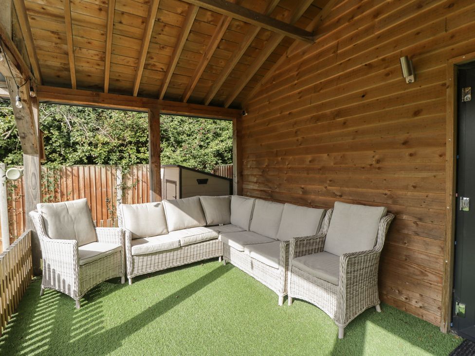 A snug area with a sofa and wooden walls at Willow Cottage in Whiteparish
