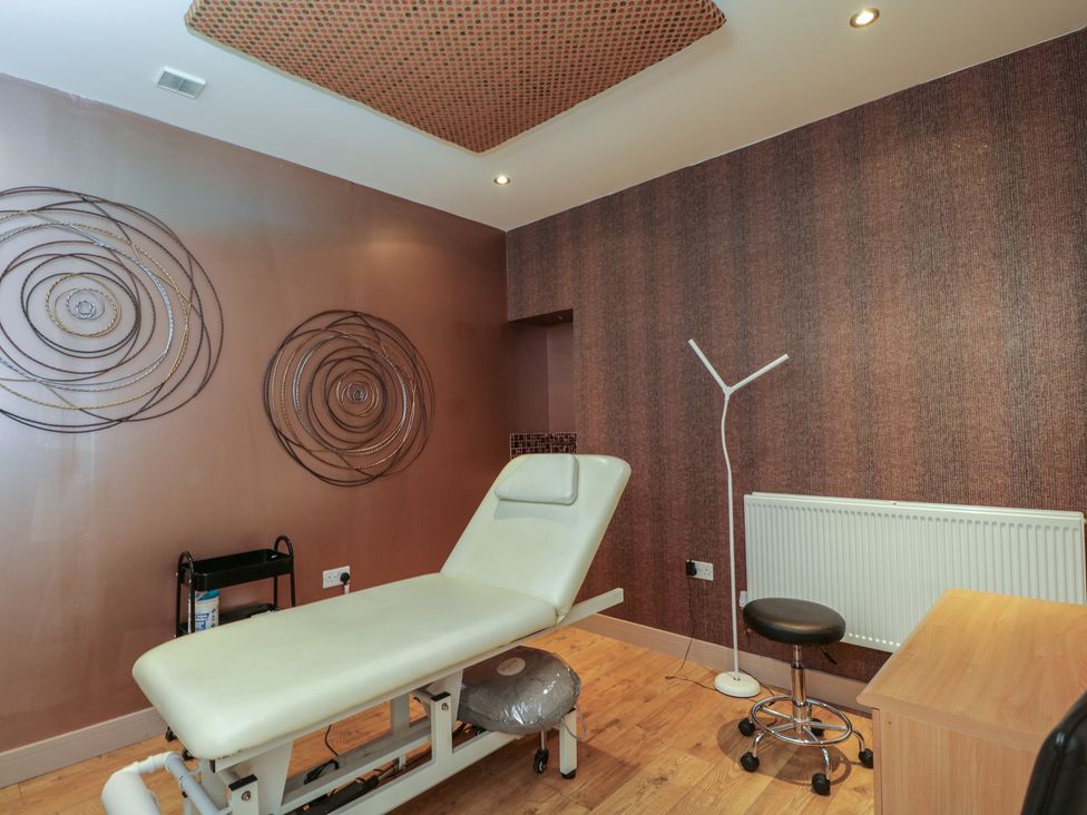 A treatment room with a table and lamp at Willow Cottage Whiteparish