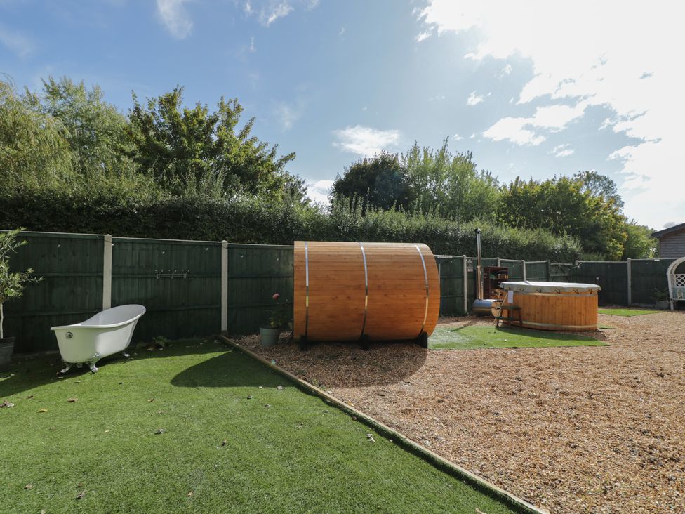 A garden with a bathtub and wooden barrel sauna at Willow Cottage in Whiteparish