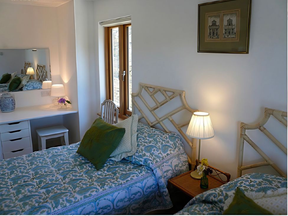 A bedroom with two beds and a desk at Cottage 2